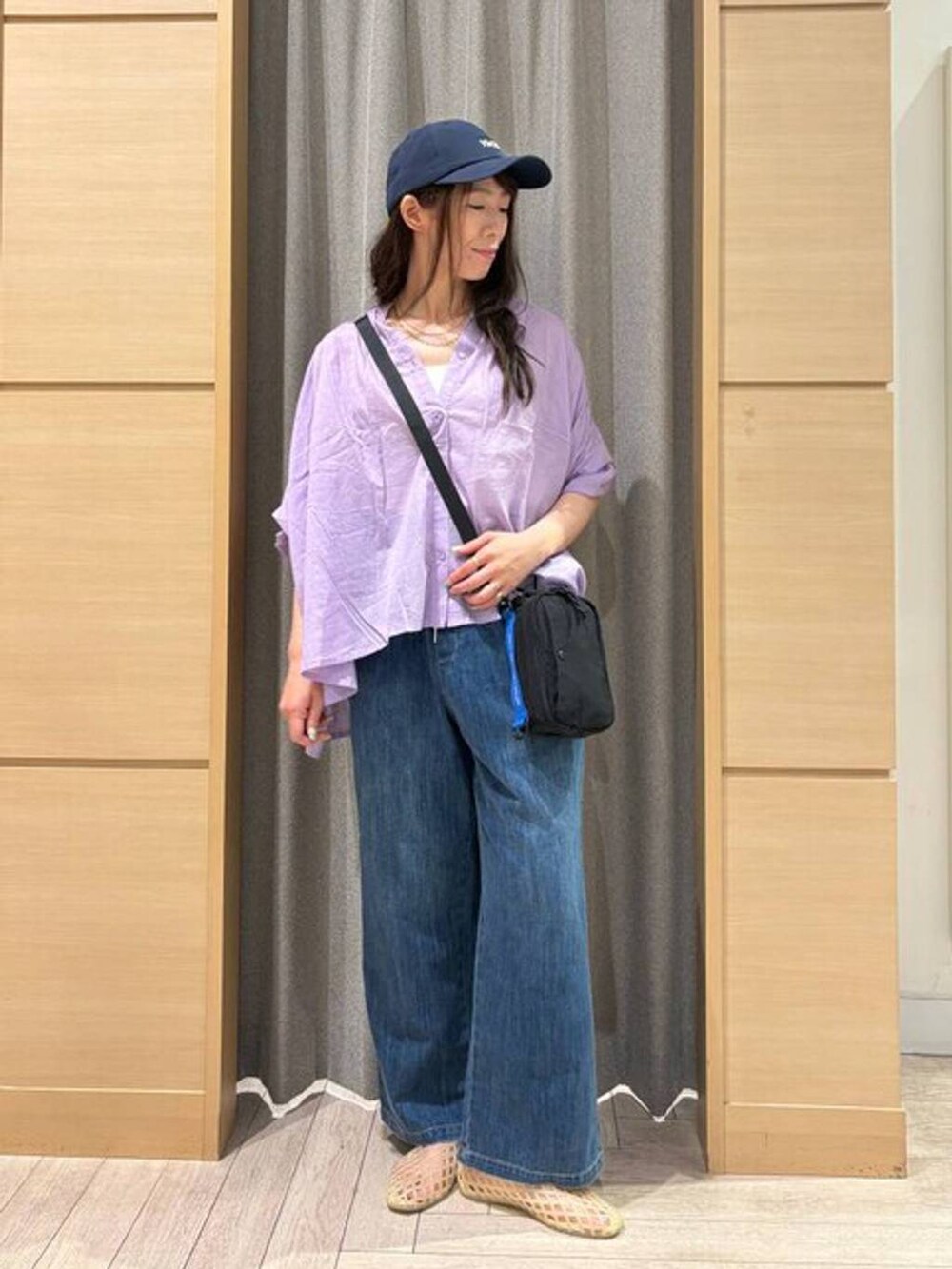ブルー系のデニムパンツ、ホワイト系のタンクトップ、ベージュ系のパンプスを着用したレディースの夏コーディネートの5枚目の写真