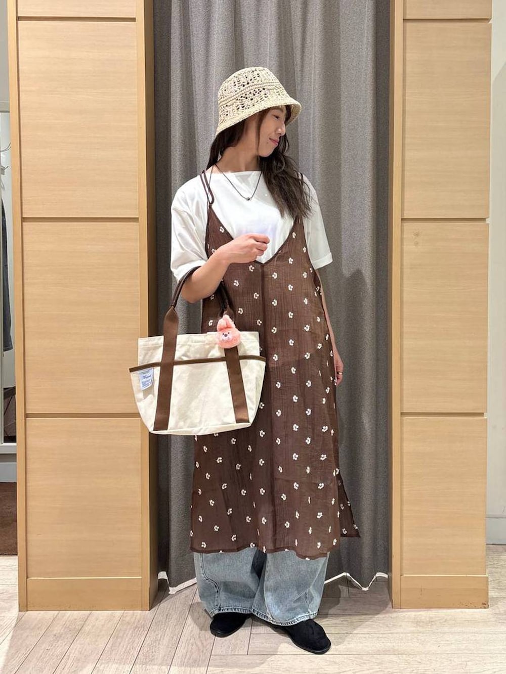 ブルー系のデニムパンツ、ベージュ系のトートバッグ、ブラック系のパンプスを着用したレディースの夏コーディネートの4枚目の写真