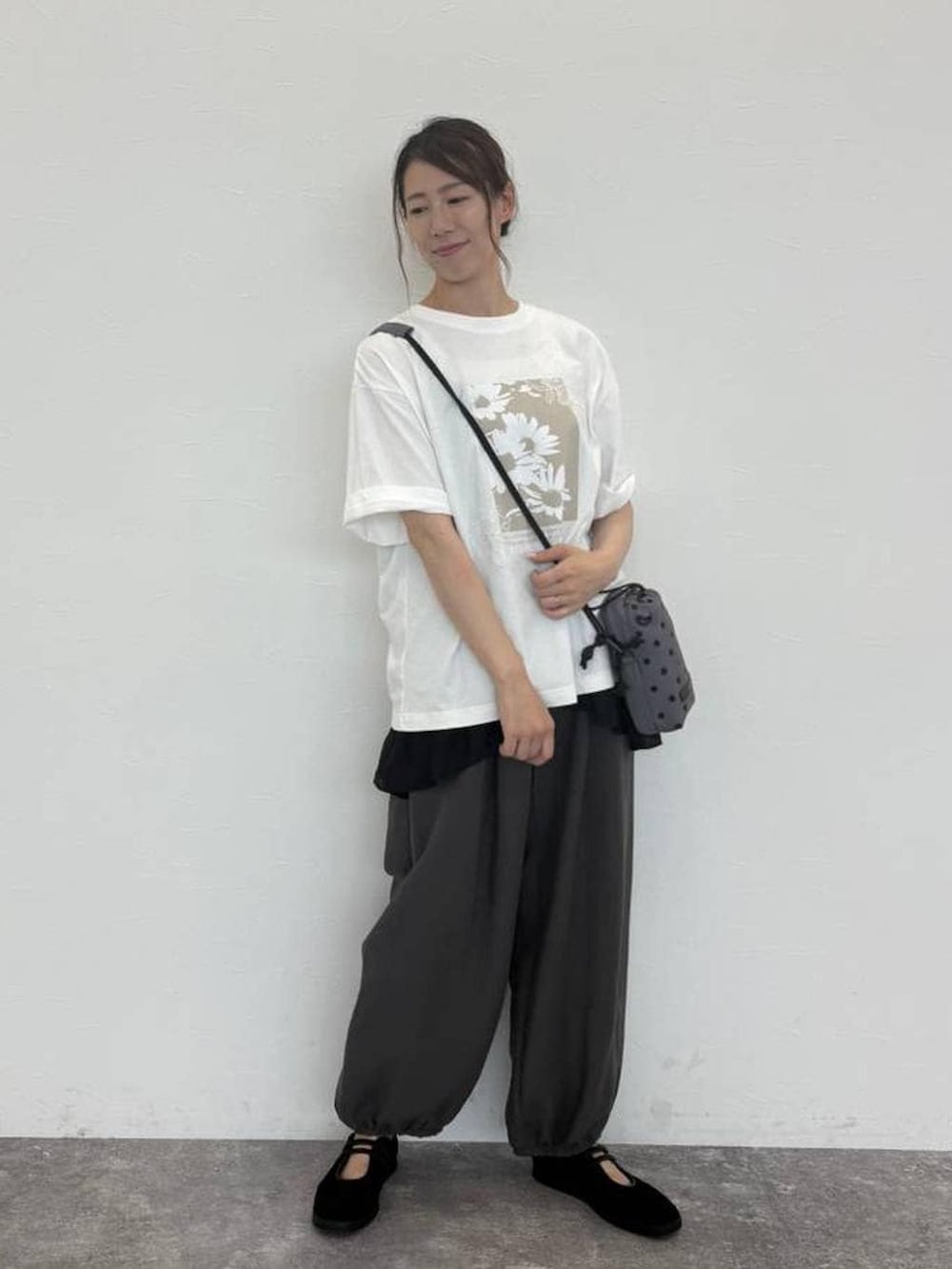 グレー系のショルダーバッグ、ホワイト系のTシャツ/カットソー、グレー系のその他パンツを着用したレディースの秋コーディネートの2枚目の写真
