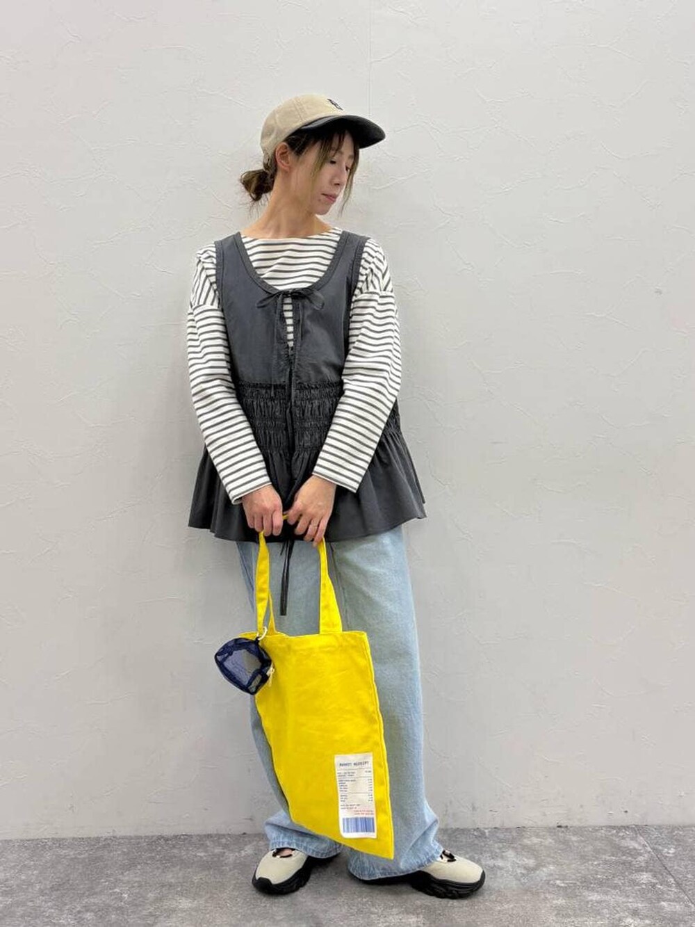 ホワイト系のスニーカー、その他のTシャツ/カットソー、イエロー系のトートバッグを着用したレディースの春コーディネートの3枚目の写真