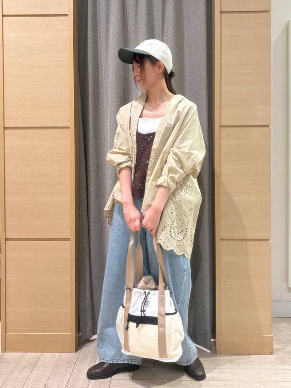 ブラウン系のベスト、ブルー系のデニムパンツ、ブラウン系のスリッポンを着用したレディースの春コーディネートの2枚目の写真