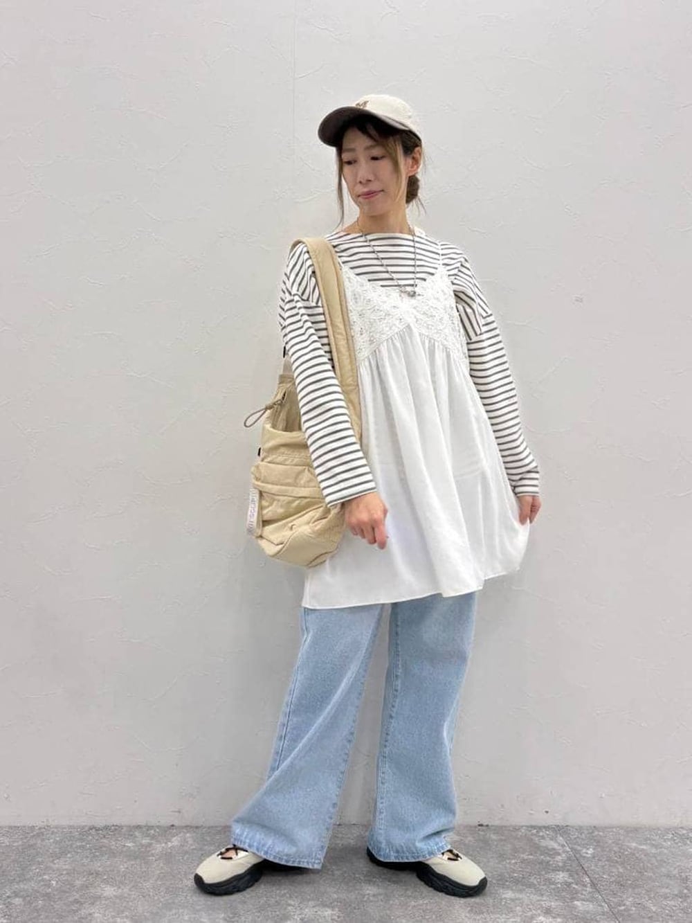 ホワイト系のスニーカー、その他のTシャツ/カットソー、ベージュ系のショルダーバッグを着用したレディースの春コーディネートの6枚目の写真