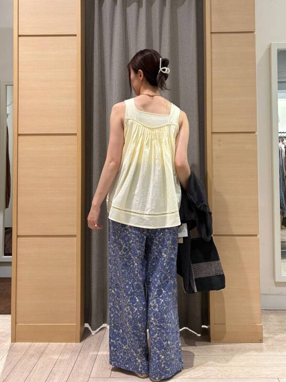 ブラック系のトートバッグ、ホワイト系のタンクトップ、ベージュ系のパンプスを着用したレディースの夏コーディネートの3枚目の写真