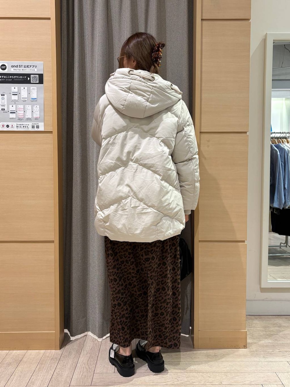 ブラック系のローファー、グレー系のダウンジャケット/コート、ブラック系のショルダーバッグを着用したレディースの冬コーディネートの2枚目の写真