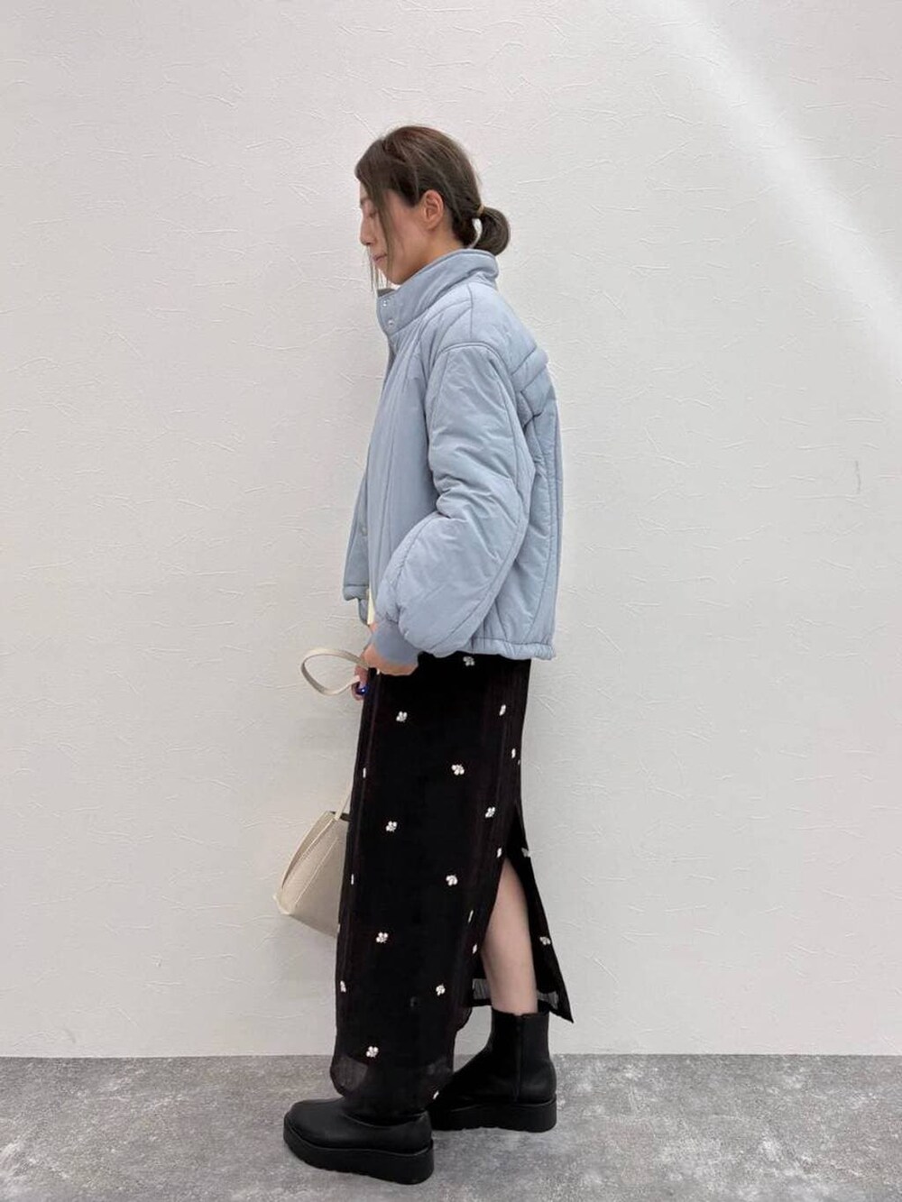 ブラック系のブーツ、ベージュ系のショルダーバッグ、ホワイト系のニット/セーターを着用したレディースの冬コーディネートの4枚目の写真