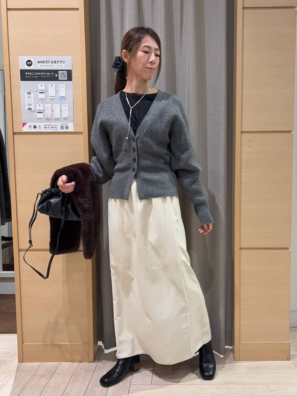 ブラック系のTシャツ/カットソー、ブラック系のブーツ、ブラック系のショルダーバッグを着用したレディースの冬コーディネートの3枚目の写真