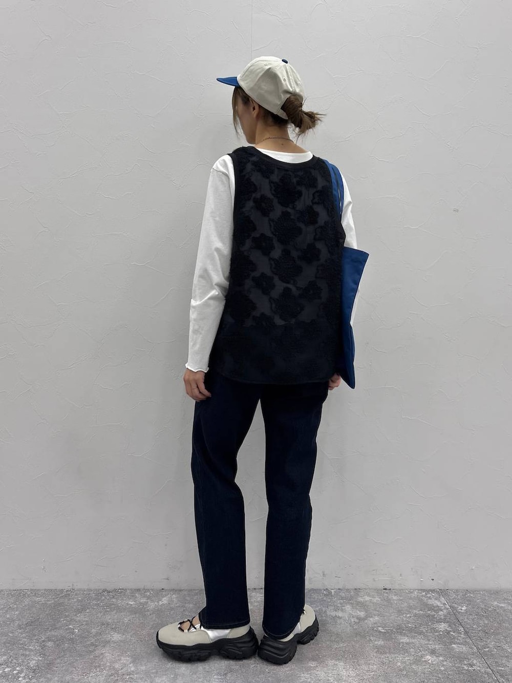 ホワイト系のスニーカー、ブラック系のTシャツ/カットソー、ブルー系のトートバッグを着用したレディースの春コーディネートの3枚目の写真