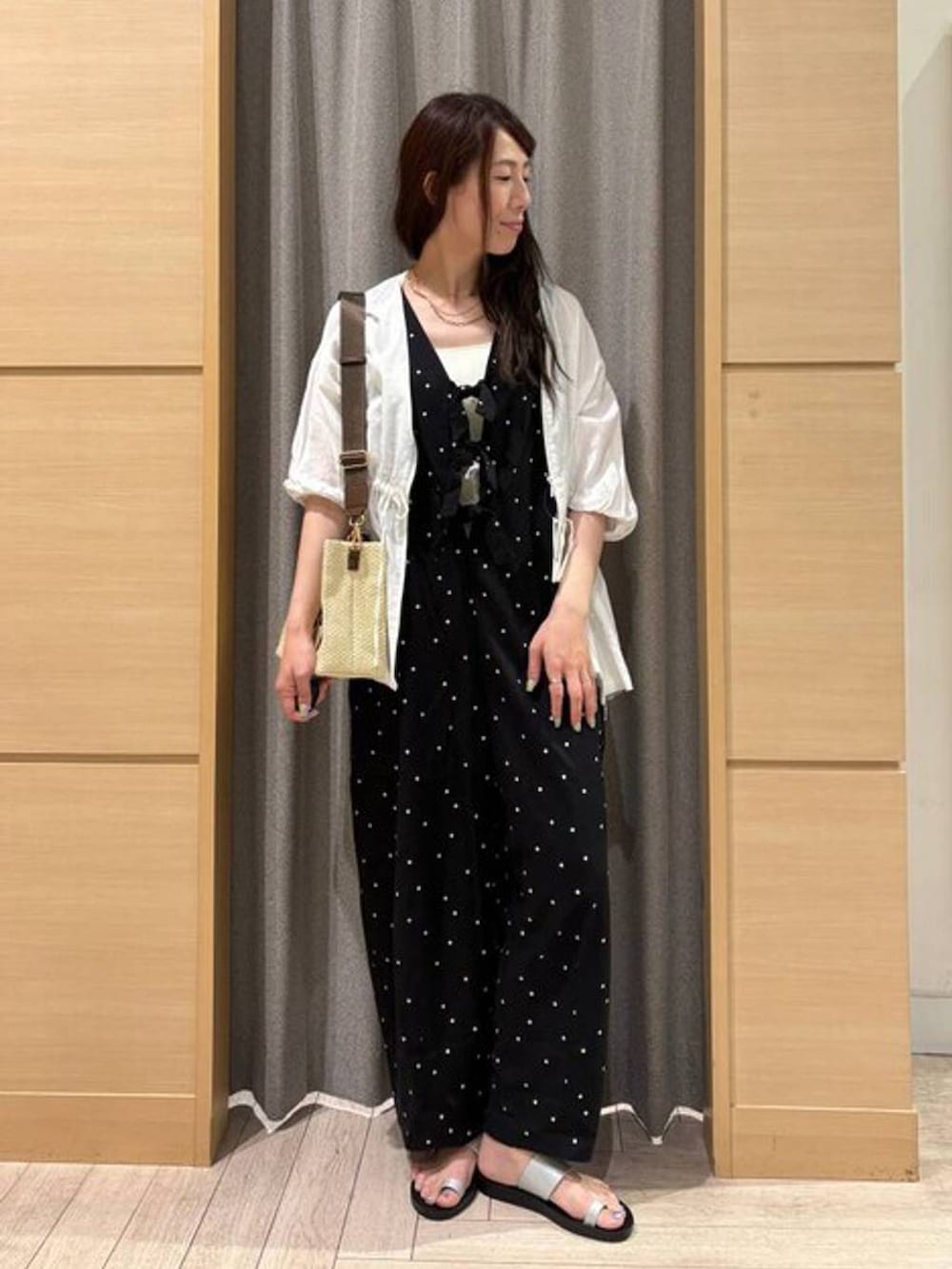 ブルー系のショルダーバッグ、シルバー系のサンダル、ホワイト系のタンクトップを着用したレディースの夏コーディネートの5枚目の写真