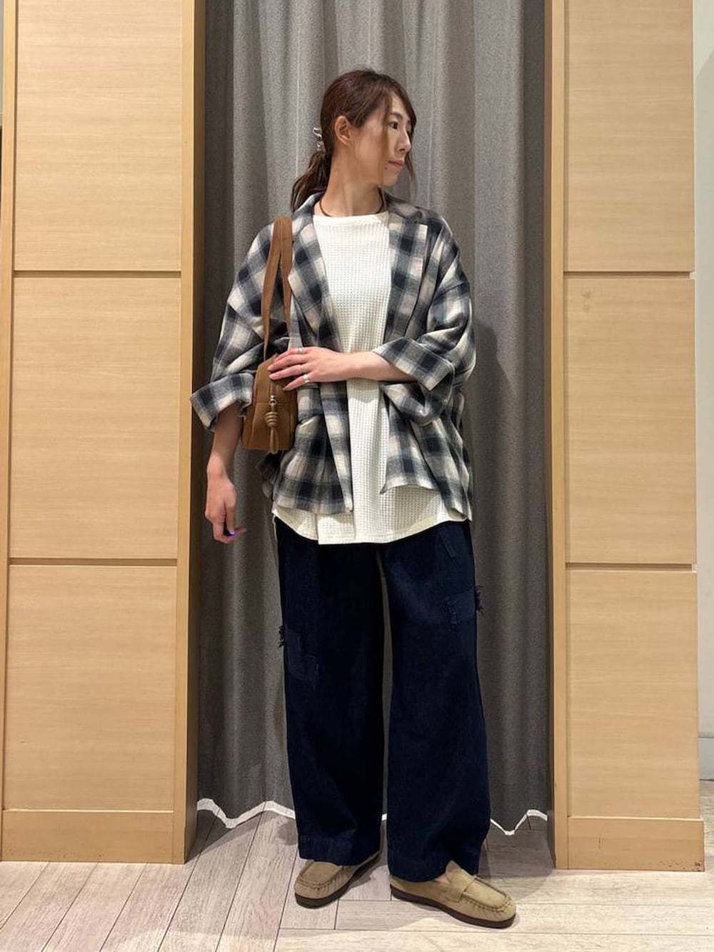 ブラウン系のショルダーバッグ、その他のテーラードジャケット、ブルー系のデニムパンツを着用したレディースの秋コーディネートの2枚目の写真