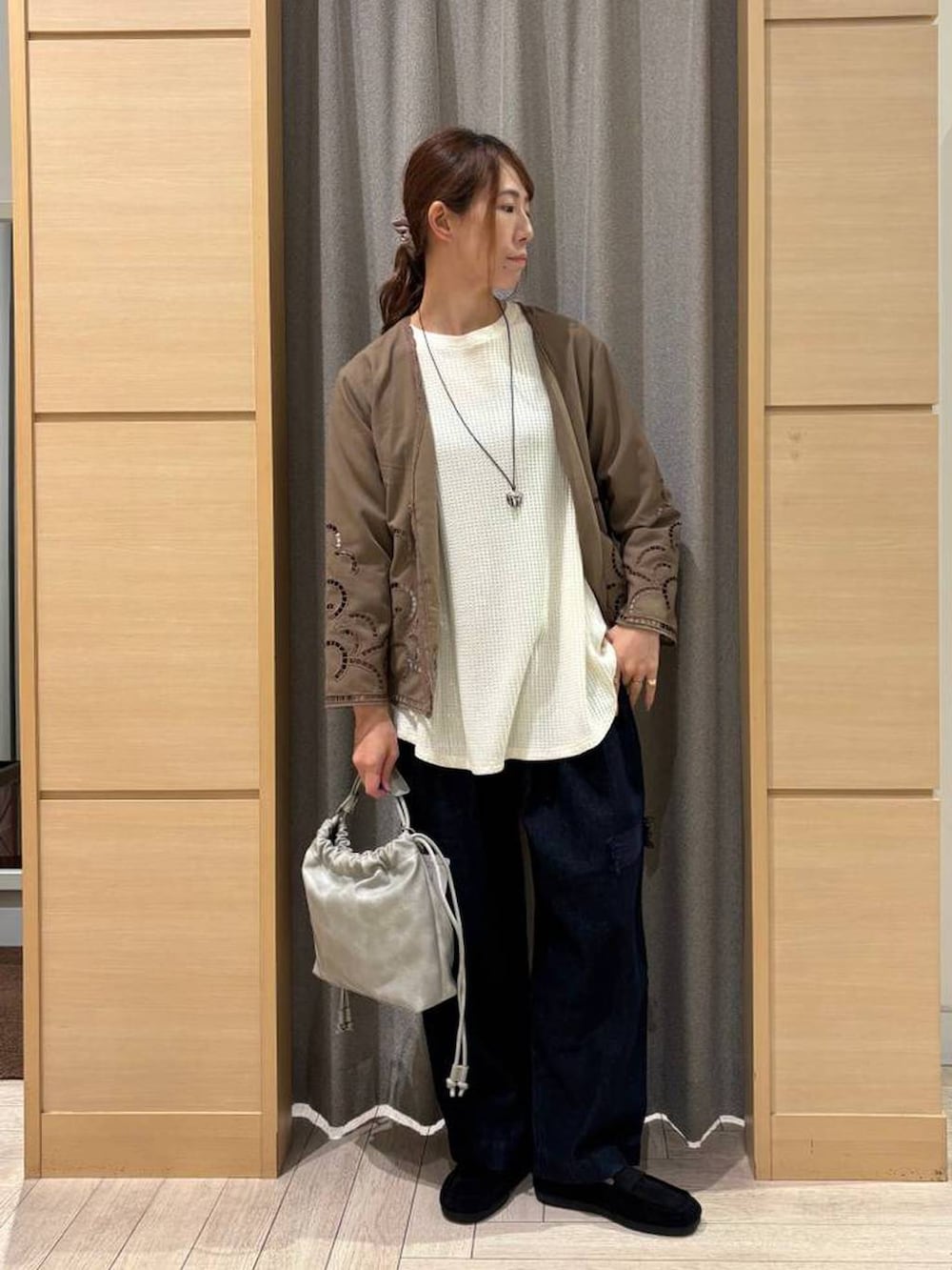 グレー系のショルダーバッグ、ブラウン系のシャツ/ブラウス、ブルー系のデニムパンツを着用したレディースの秋コーディネートの4枚目の写真