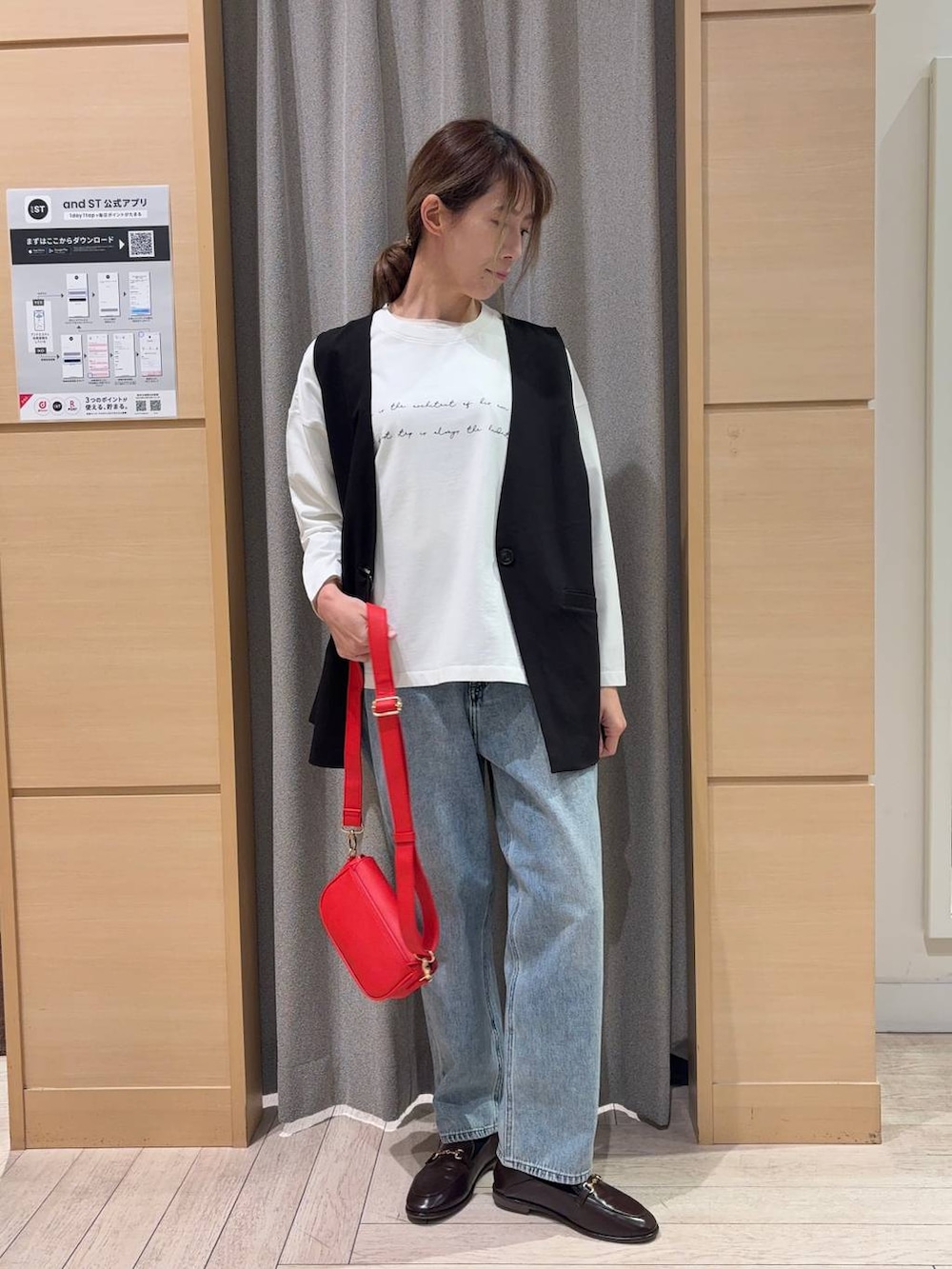 ブラック系のベスト、その他のTシャツ/カットソー、ブルー系のデニムパンツを着用したレディースの春コーディネートの4枚目の写真