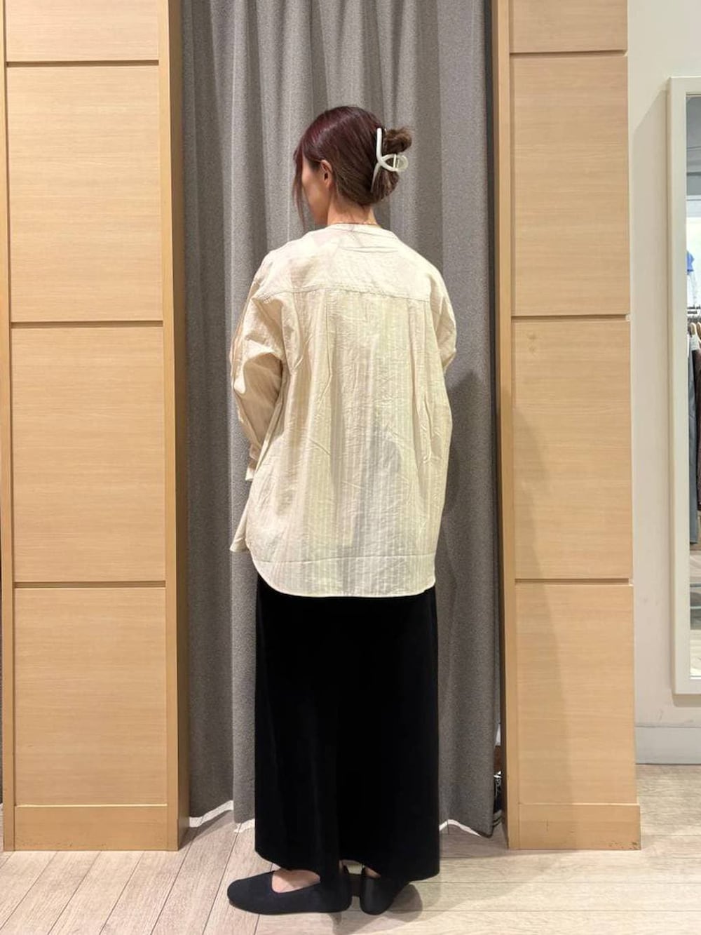 ブラック系のスカート、グレー系のパンプス、ホワイト系のタンクトップを着用したレディースの春コーディネートの2枚目の写真