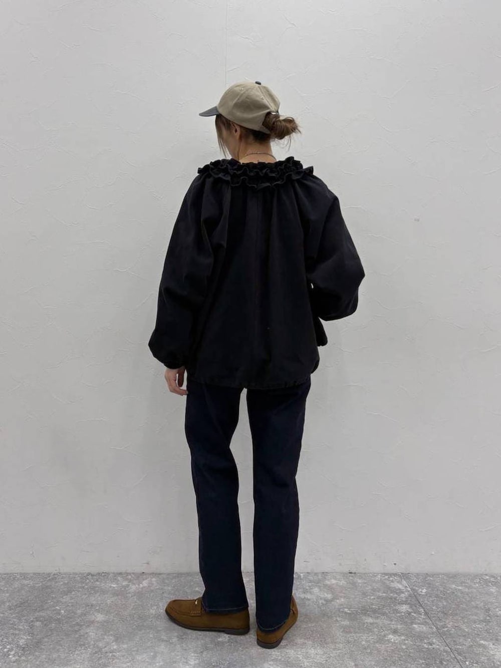 ブラウン系のベスト、ブラック系のブルゾン、ベージュ系のTシャツ/カットソーを着用したレディースの春コーディネートの4枚目の写真