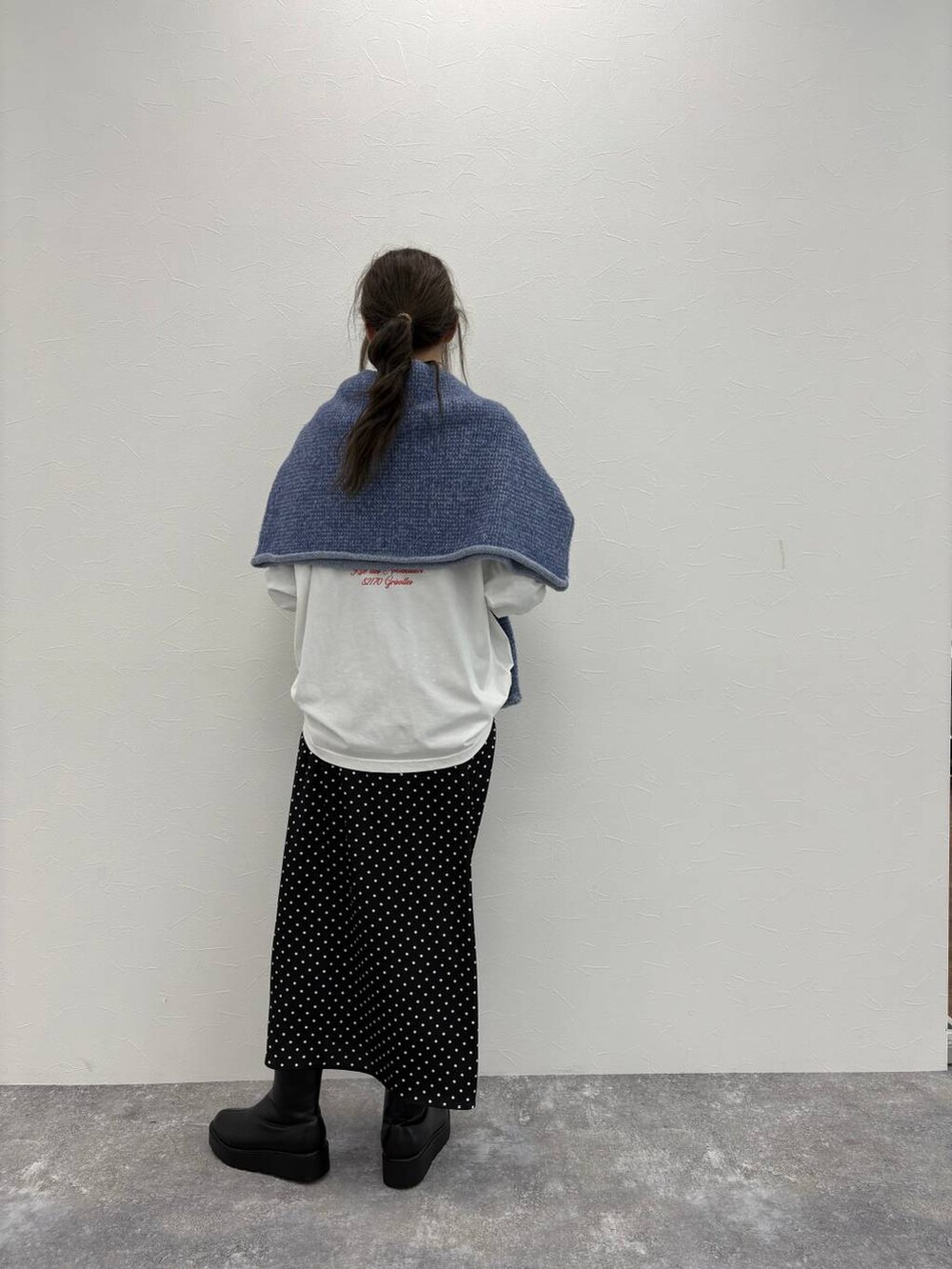 ブラック系のブーツ、その他のスカート、ホワイト系のTシャツ/カットソーを着用したレディースの冬コーディネートの3枚目の写真