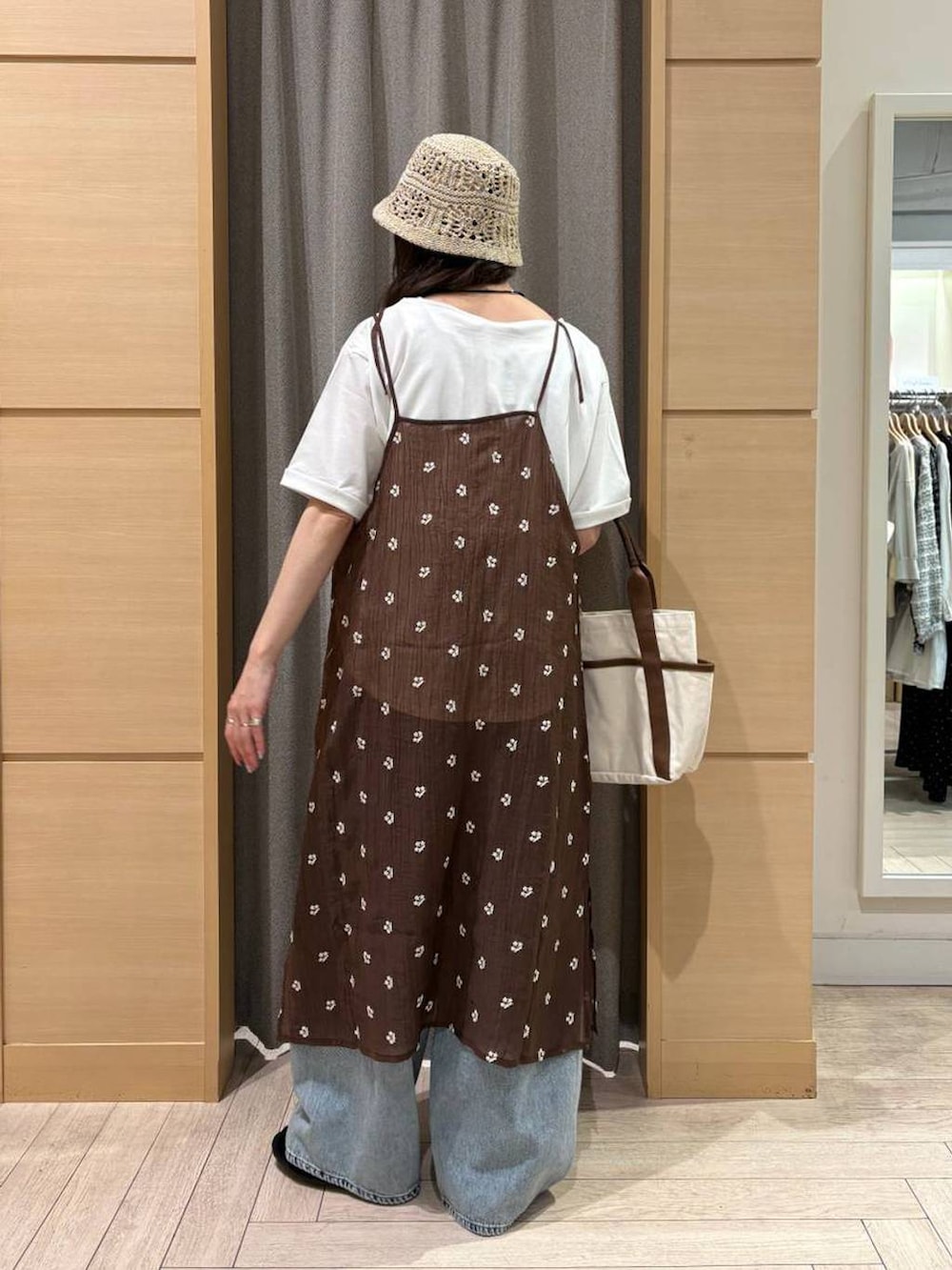 ブルー系のデニムパンツ、ベージュ系のトートバッグ、ブラック系のパンプスを着用したレディースの夏コーディネートの5枚目の写真