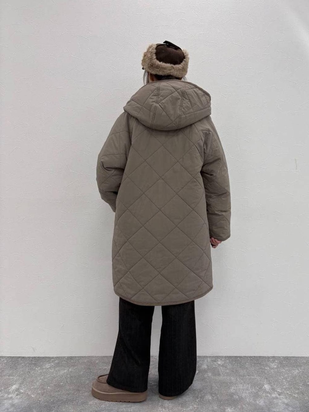 グレー系のブーツ、ブラウン系のダウンジャケット/コート、グレー系のスラックスを着用したレディースの冬コーディネートの3枚目の写真