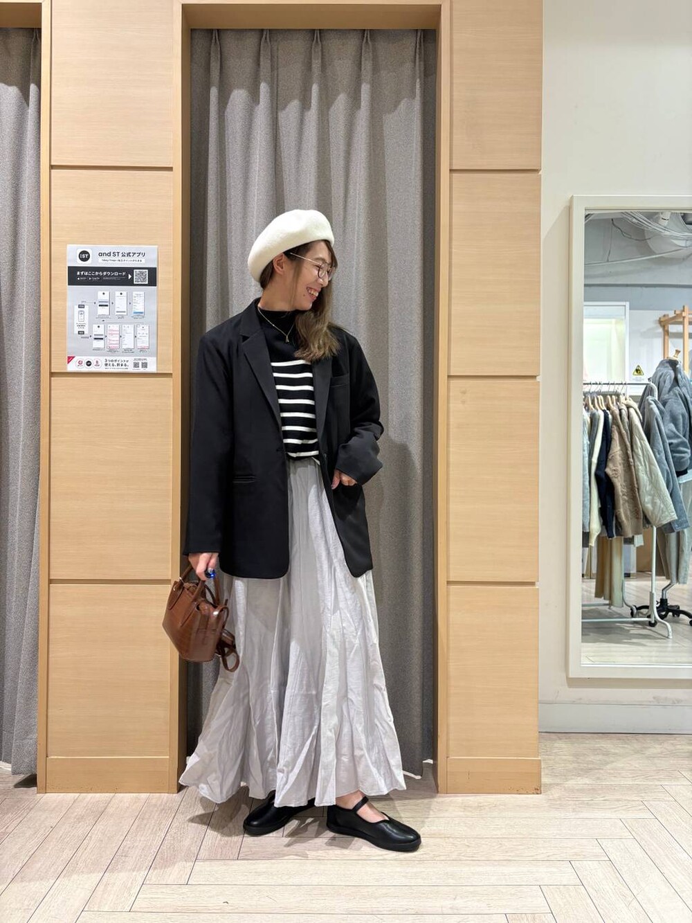 ブラック系のスニーカー、ブラウン系のトートバッグ、その他のニット/セーターを着用したレディースの冬コーディネートの2枚目の写真