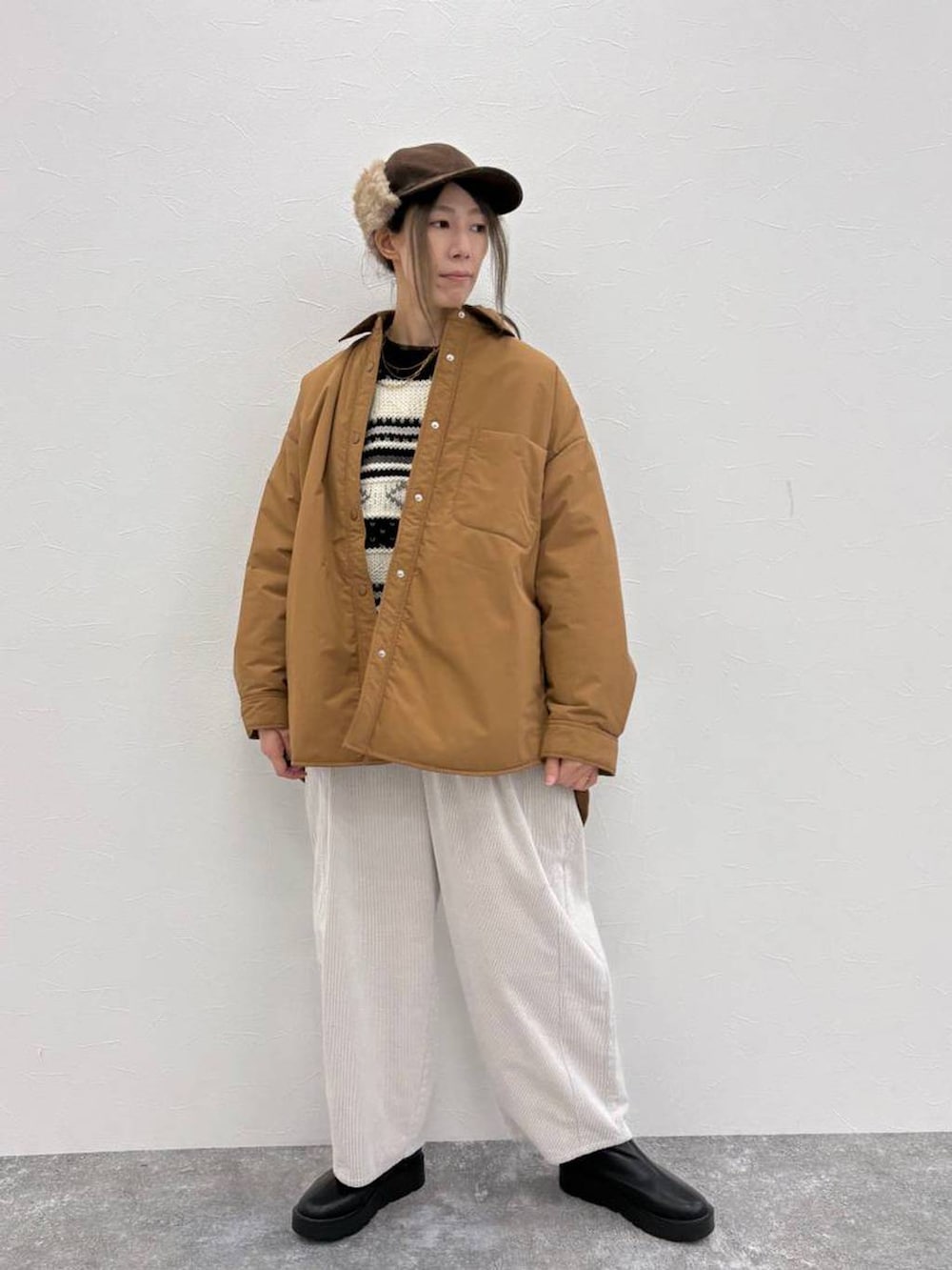 ブラウン系のその他アウター、ブラック系のブーツ、グレー系のその他パンツを着用したレディースの冬コーディネートの2枚目の写真