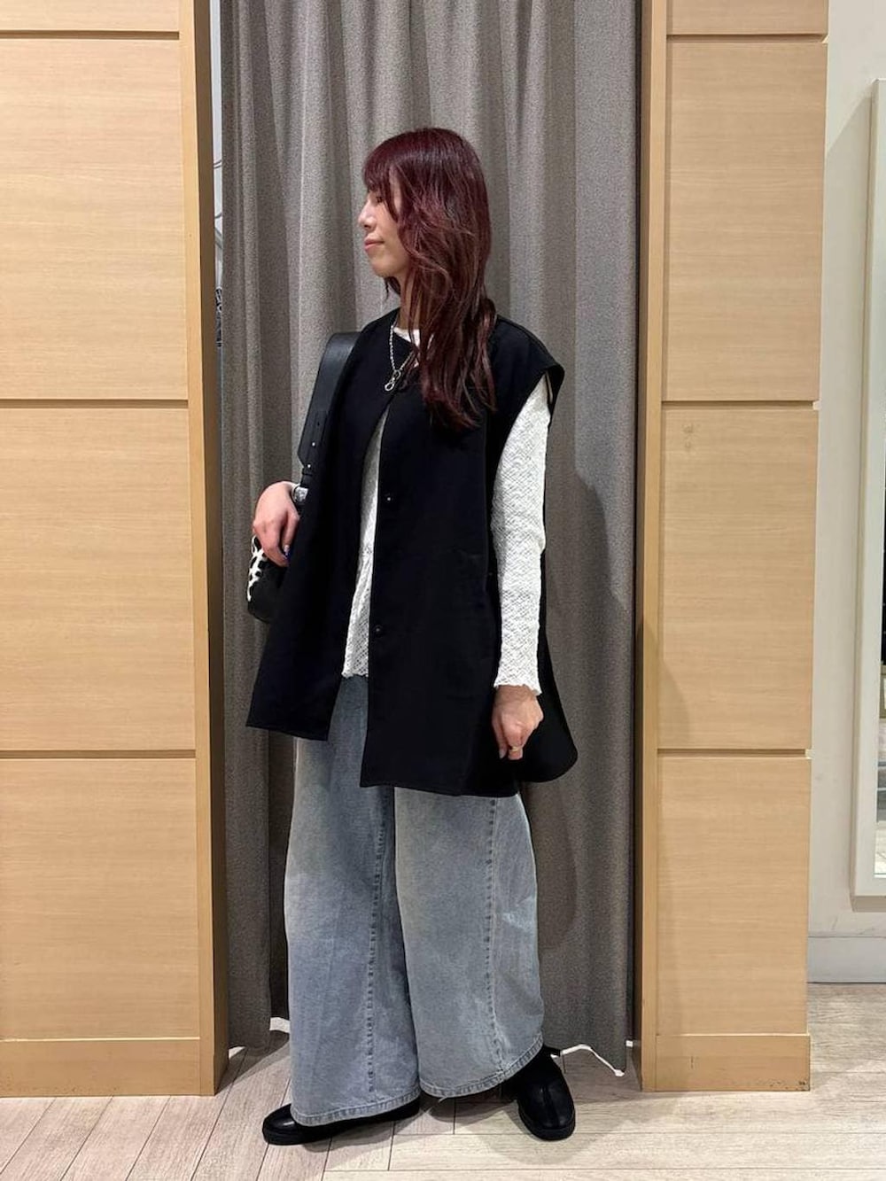 ブルー系のデニムパンツ、ブラック系のスニーカー、ホワイト系のTシャツ/カットソーを着用したレディースの春コーディネートの2枚目の写真