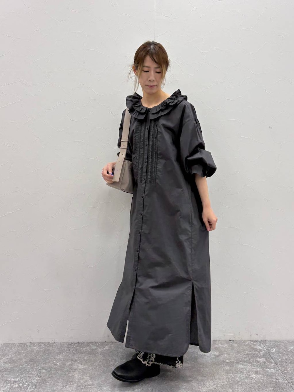 グレー系のショルダーバッグ、ブラック系のワンピース、ブラック系のその他パンツを着用したレディースの冬コーディネートの3枚目の写真