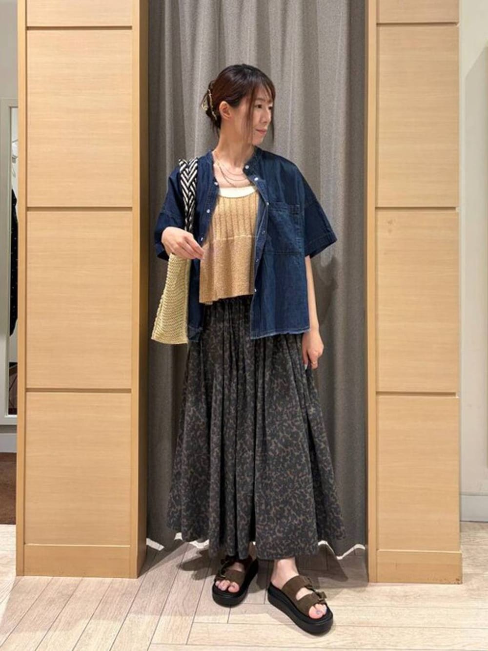 ベージュ系のトートバッグ、グリーン系のサンダル、ベージュ系のタンクトップを着用したレディースの夏コーディネートの3枚目の写真