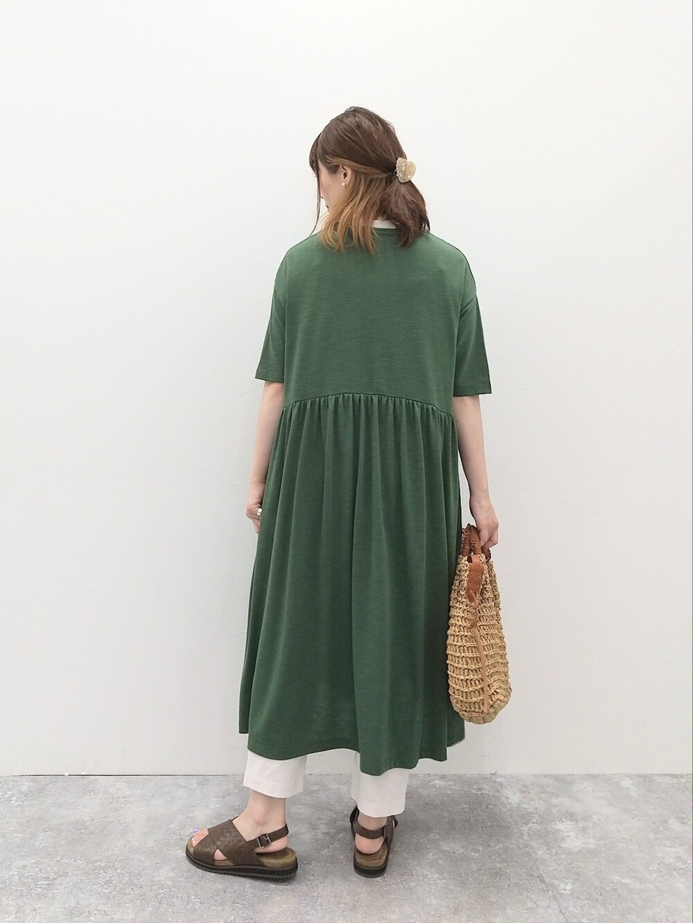 ベージュ系のトートバッグ、グレー系のTシャツ/カットソー、グリーン系のワンピースを着用したレディースの夏コーディネートの2枚目の写真