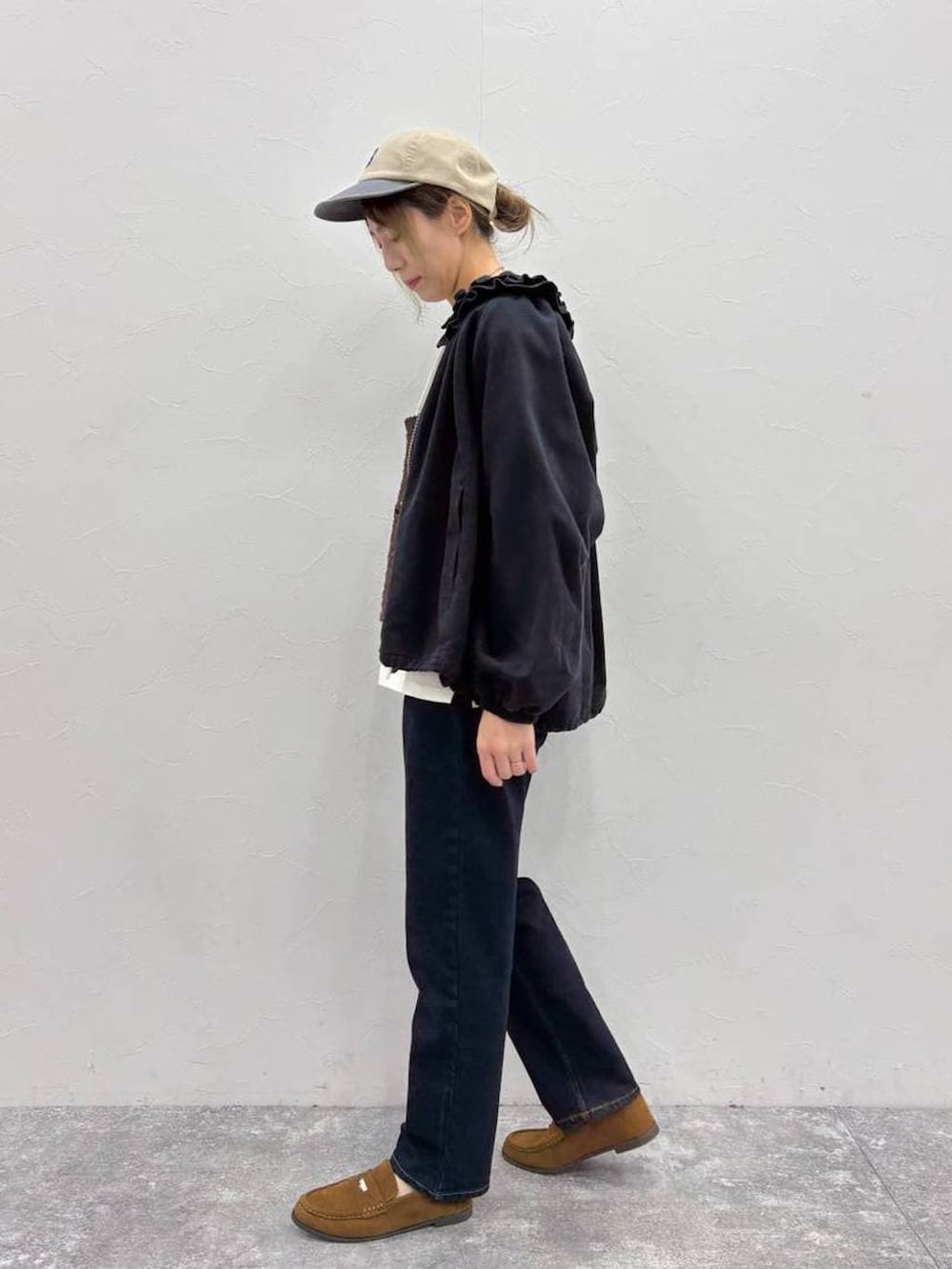 ブラウン系のベスト、ブラック系のブルゾン、ベージュ系のTシャツ/カットソーを着用したレディースの春コーディネートの3枚目の写真