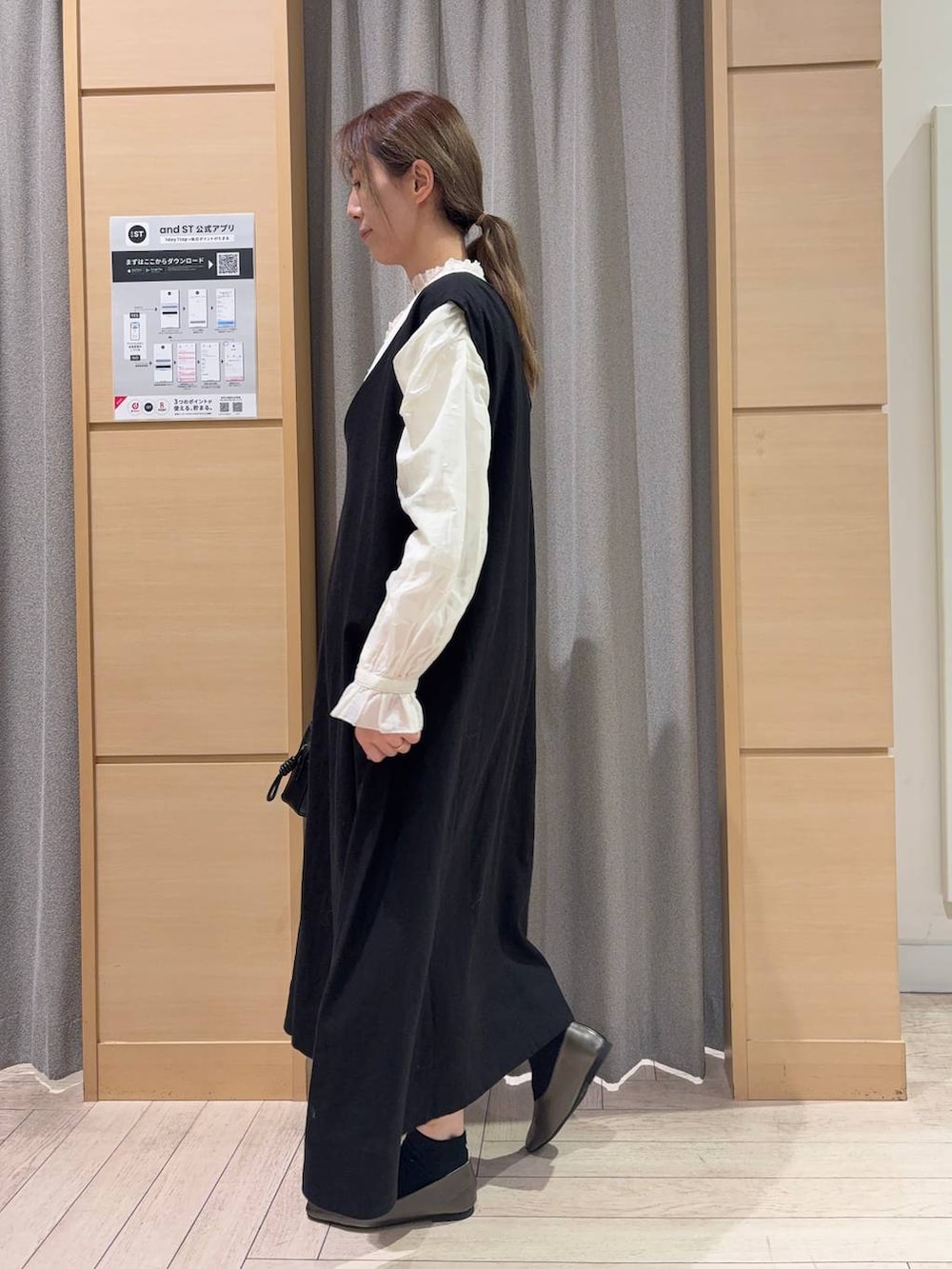 ブラック系のトートバッグ、ホワイト系のシャツ/ブラウス、ブラック系のジャンパースカートを着用したレディースの冬コーディネートの4枚目の写真