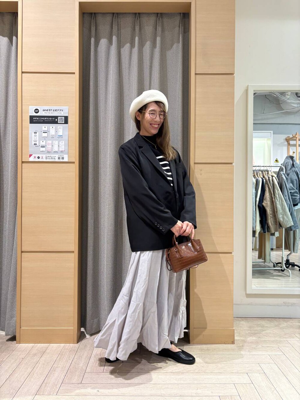 ブラック系のスニーカー、ブラウン系のトートバッグ、その他のニット/セーターを着用したレディースの冬コーディネートの3枚目の写真