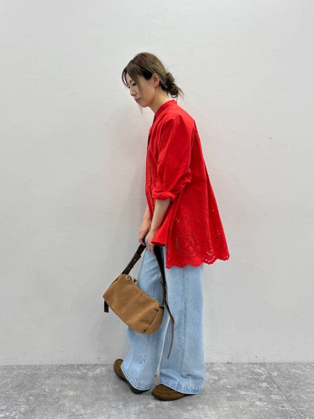 イエロー系のローファー、ブラウン系のショルダーバッグ、ブルー系のデニムパンツを着用したレディースの春コーディネートの3枚目の写真