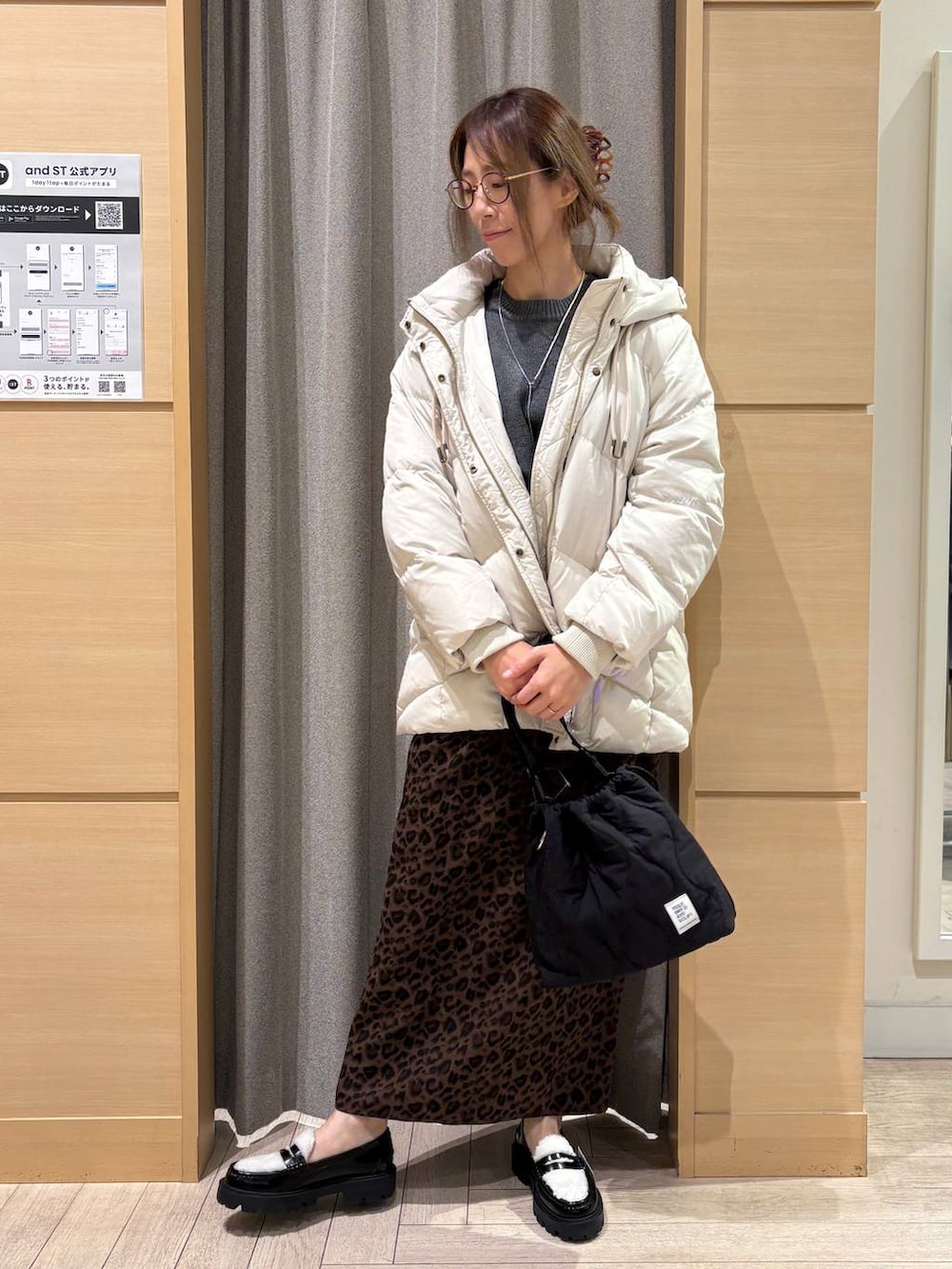 ベージュ系のダウンジャケット/コート、ブラック系のショルダーバッグ、その他のスカートを着用したレディースの冬コーディネートの2枚目の写真