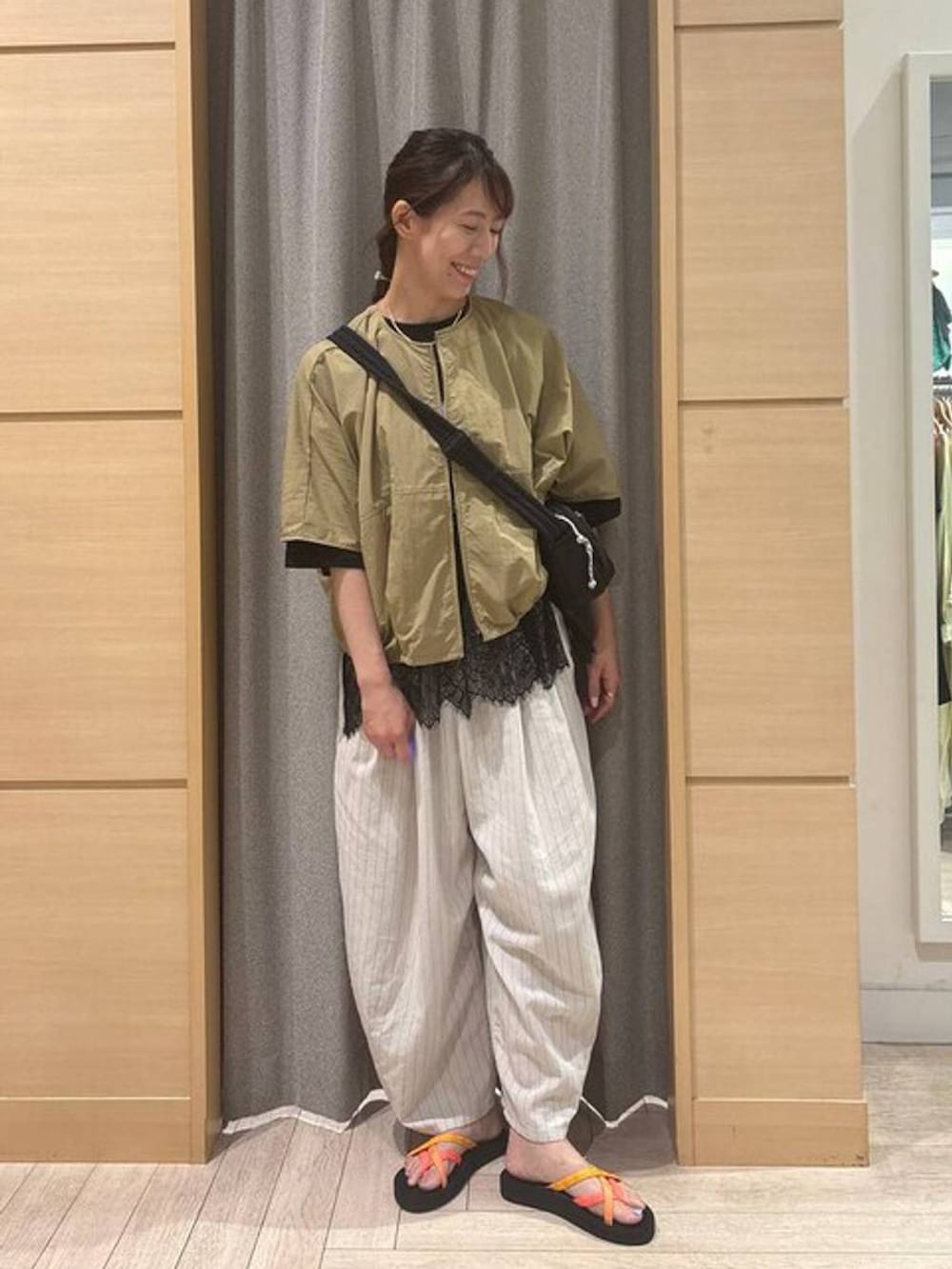 オレンジ系のサンダル、その他のその他パンツ、ブラック系のTシャツ/カットソーを着用したレディースの夏コーディネートの2枚目の写真