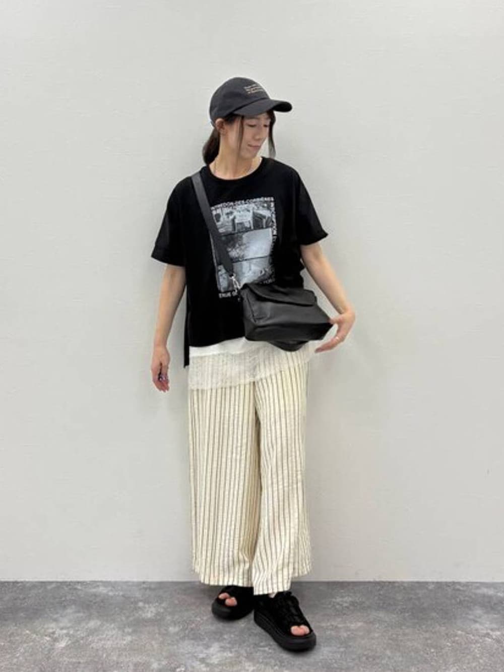 ブラック系のサンダル、ブラック系のTシャツ/カットソー、ブラック系のショルダーバッグを着用したレディースの夏コーディネートの5枚目の写真