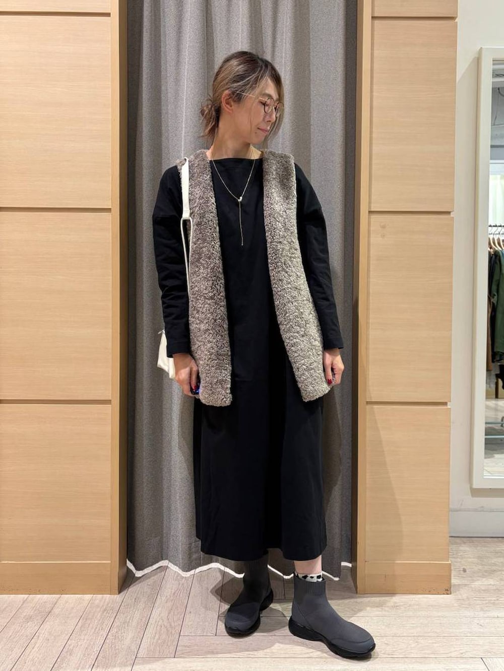 その他のベスト、グレー系のブーツ、ブラック系のショルダーバッグを着用したレディースの秋コーディネートの4枚目の写真