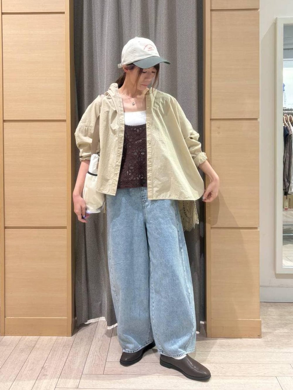 ブラウン系のベスト、ブルー系のデニムパンツ、ブラウン系のスリッポンを着用したレディースの春コーディネートの5枚目の写真