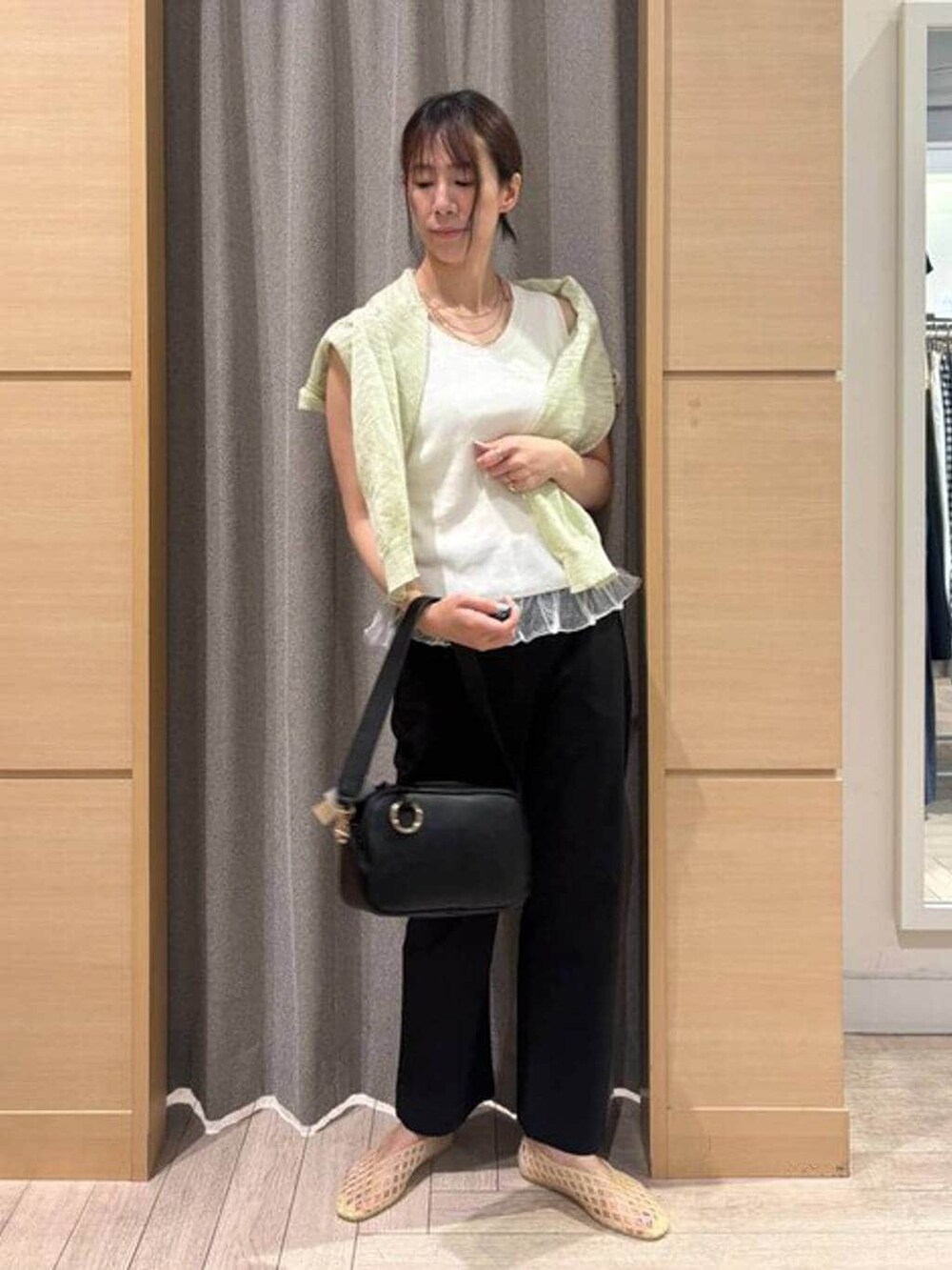 ブラック系のその他パンツ、ブラック系のショルダーバッグ、ベージュ系のパンプスを着用したレディースの夏コーディネートの2枚目の写真