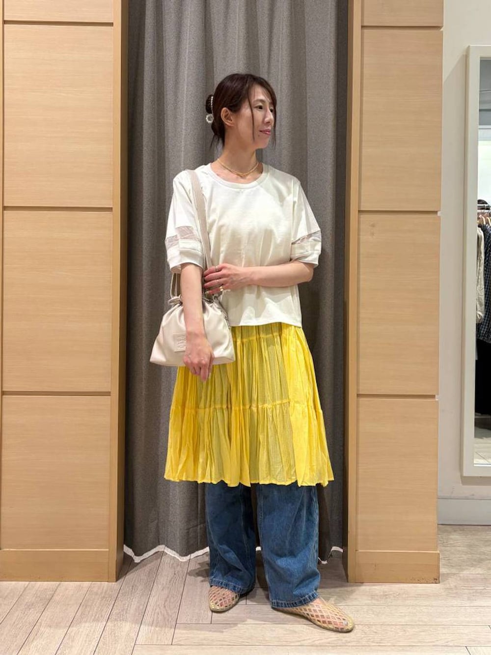ホワイト系のTシャツ/カットソー、ブルー系のデニムパンツ、ベージュ系のパンプスを着用したレディースの秋コーディネートの2枚目の写真