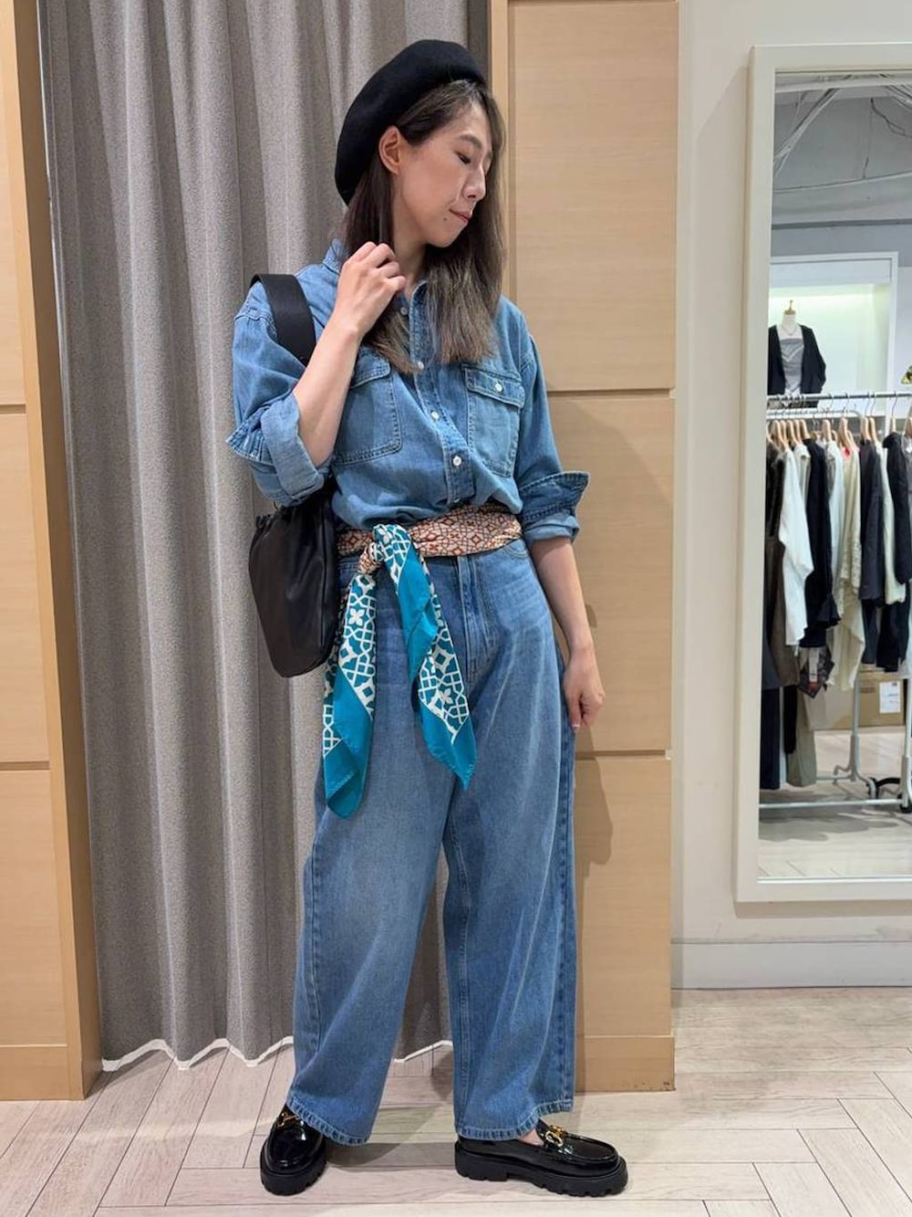 ブラック系のローファー、ブラック系のショルダーバッグ、ブルー系のデニムパンツを着用したレディースの秋コーディネートの3枚目の写真