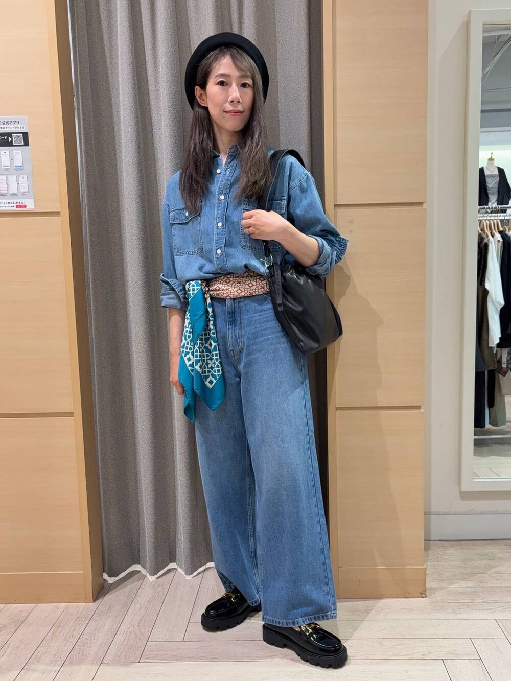 ブラック系のローファー、ブラック系のショルダーバッグ、ブルー系のデニムパンツを着用したレディースの秋コーディネートの2枚目の写真