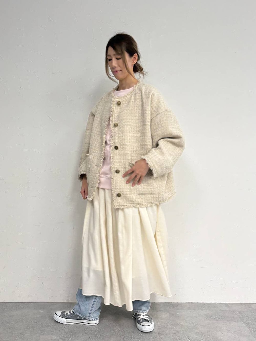 ブルー系のデニムパンツ、ベージュ系のスカート、ベージュ系のノーカラージャケットを着用したレディースの冬コーディネートの4枚目の写真