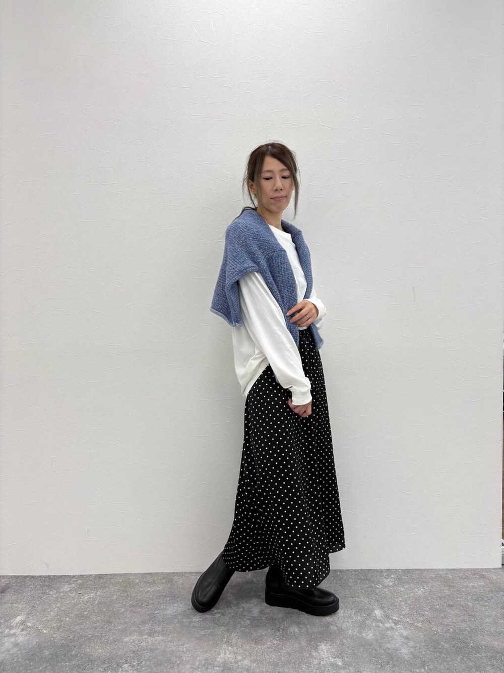 ブラック系のブーツ、その他のスカート、ホワイト系のTシャツ/カットソーを着用したレディースの冬コーディネートの2枚目の写真