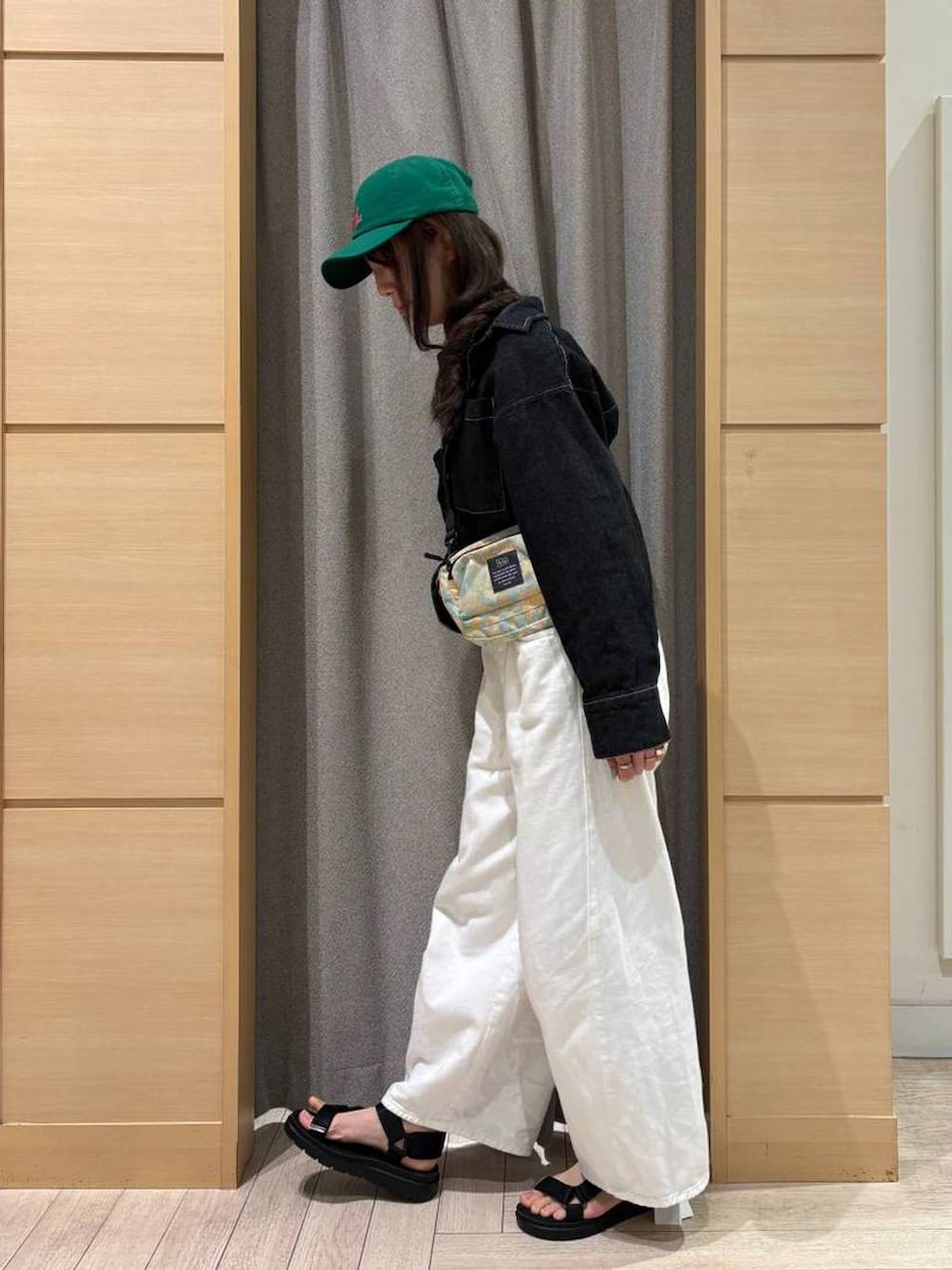 ホワイト系のデニムパンツ、ブラック系のサンダル、ブラック系のシャツ/ブラウスを着用したレディースの春コーディネートの2枚目の写真