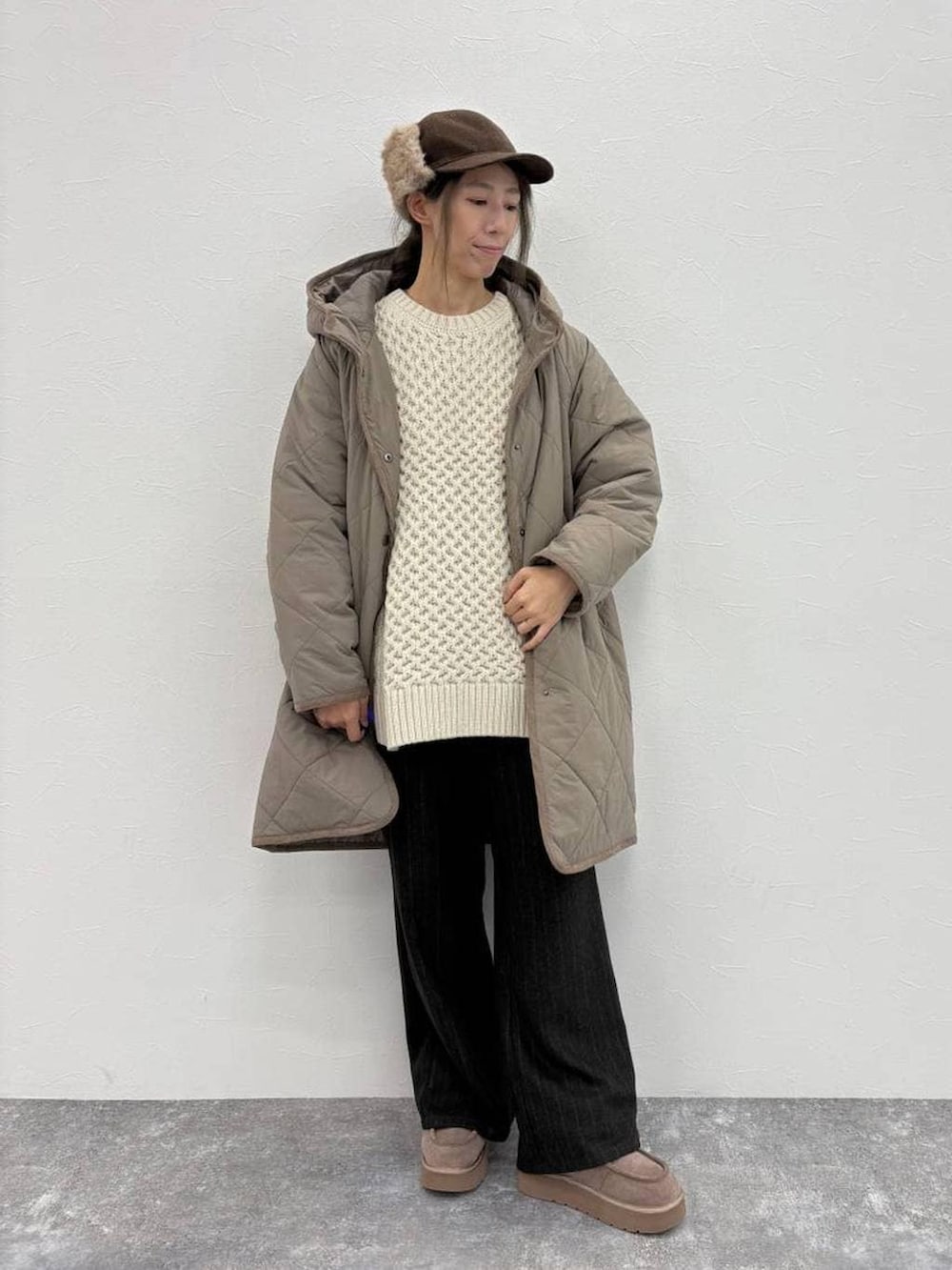 グレー系のブーツ、ブラウン系のダウンジャケット/コート、グレー系のスラックスを着用したレディースの冬コーディネートの4枚目の写真