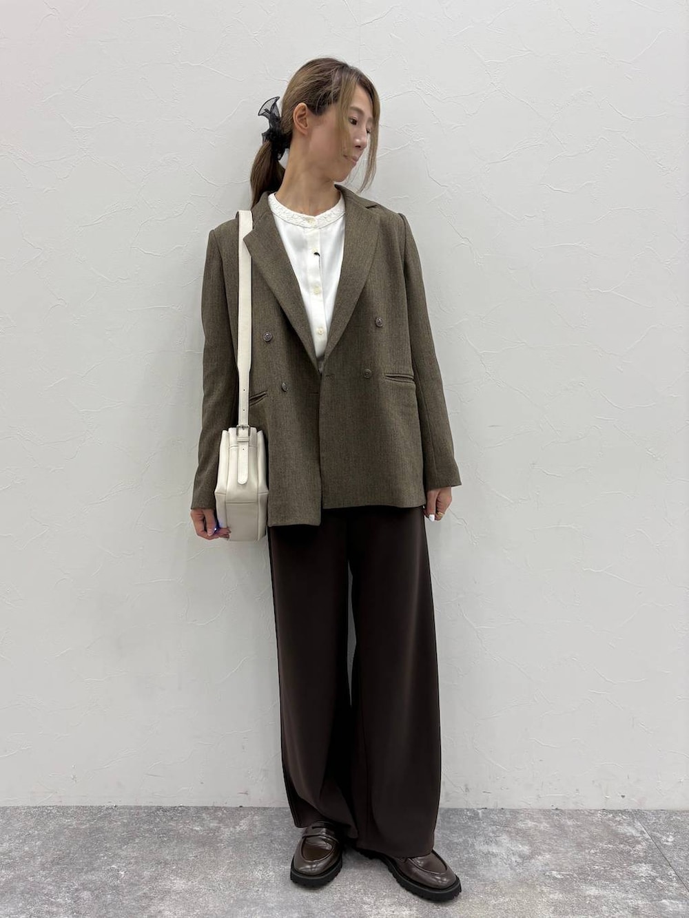 ブラウン系のテーラードジャケット、ホワイト系のシャツ/ブラウス、ブラウン系のローファーを着用したレディースの秋コーディネートの7枚目の写真