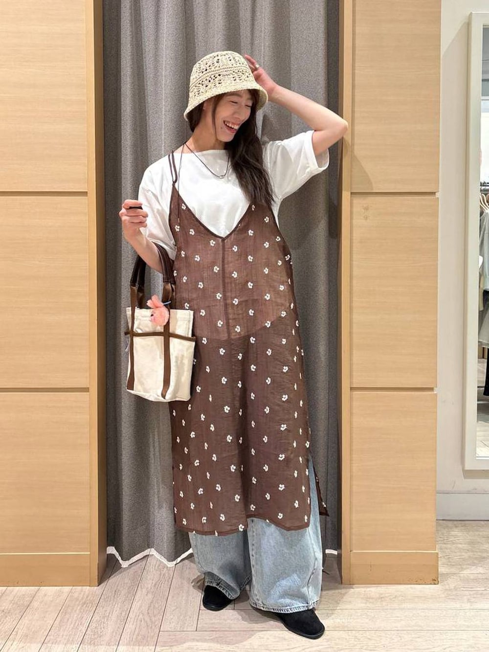 ブルー系のデニムパンツ、ベージュ系のトートバッグ、ブラック系のパンプスを着用したレディースの夏コーディネートの6枚目の写真