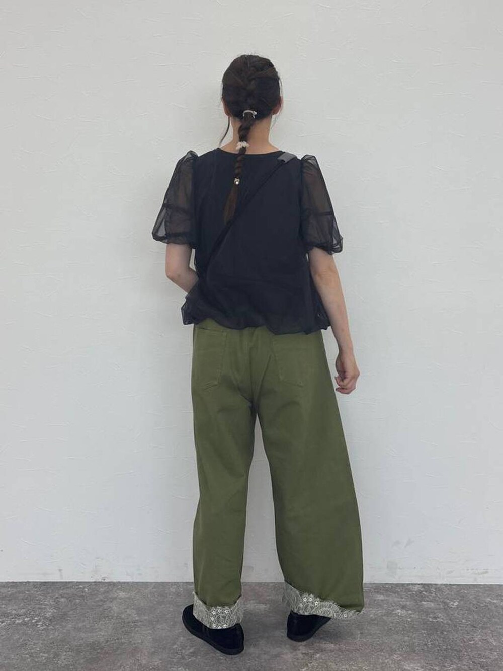 グリーン系のデニムパンツ、グレー系のショルダーバッグ、ブラック系のスニーカーを着用したレディースの秋コーディネートの2枚目の写真