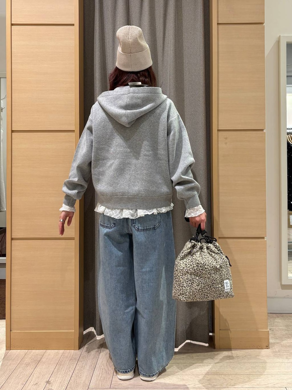 ブルー系のデニムパンツ、ベージュ系のショルダーバッグ、ホワイト系のTシャツ/カットソーを着用したレディースの春コーディネートの2枚目の写真