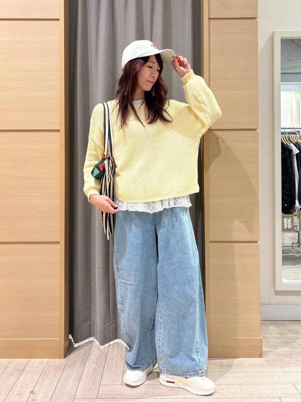 ブルー系のデニムパンツ、ホワイト系のTシャツ/カットソー、ベージュ系のトートバッグを着用したレディースの春コーディネートの4枚目の写真