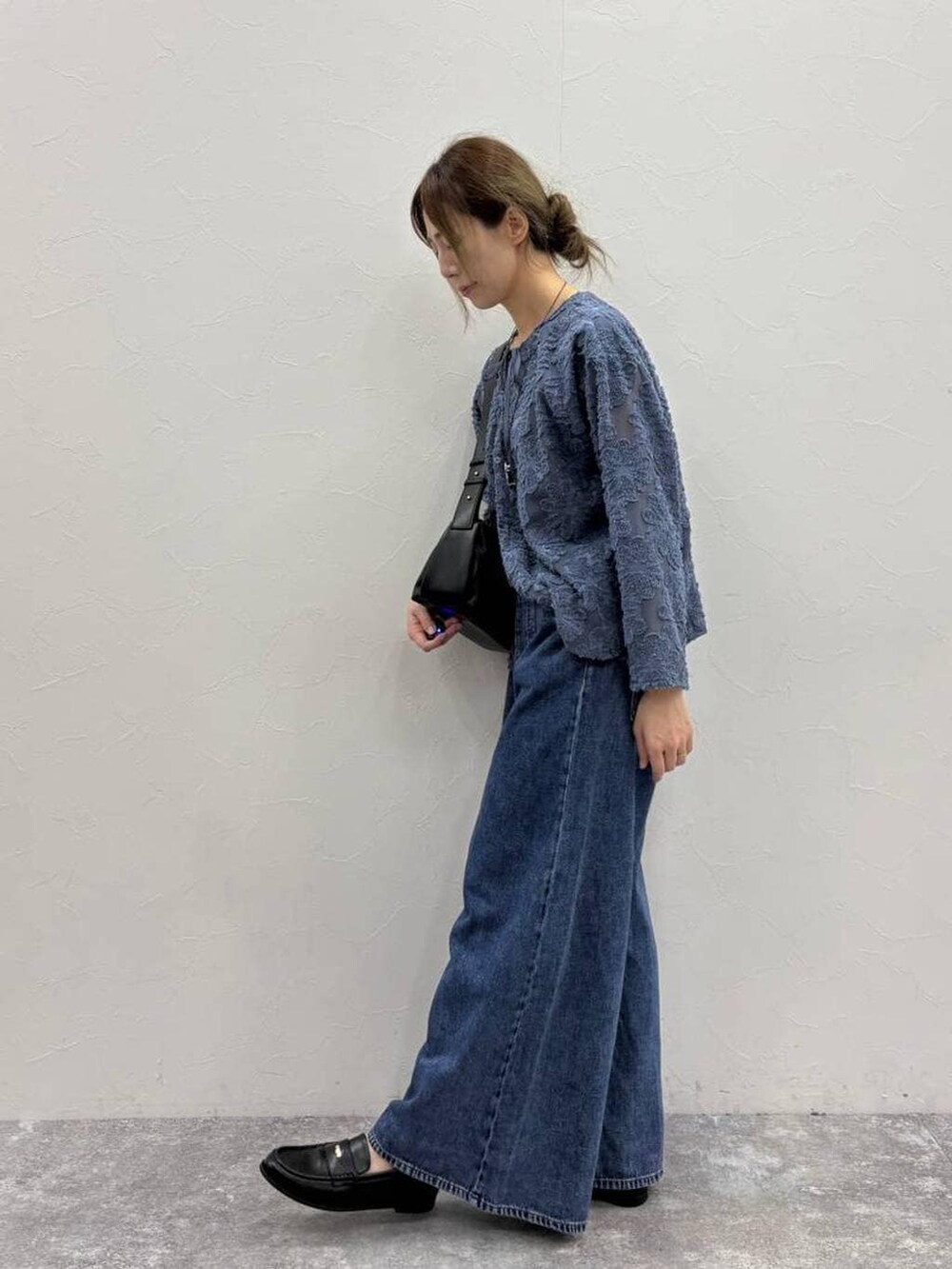 ブラック系のTシャツ/カットソー、ブルー系のデニムパンツ、ブラック系のローファーを着用したレディースの春コーディネートの4枚目の写真