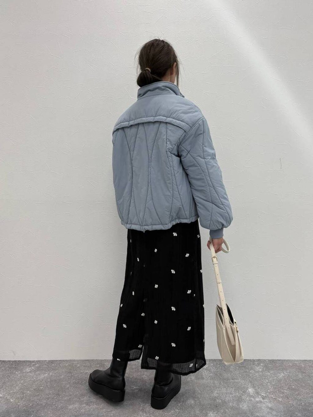 ブラック系のブーツ、ベージュ系のショルダーバッグ、ホワイト系のニット/セーターを着用したレディースの冬コーディネートの5枚目の写真